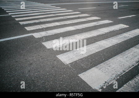 Gestreift weiß Zebra auf grauem Asphalt auf der anderen Straßenseite Stockfoto