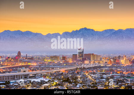 Toyama, Japan Downtown Skyline der Stadt mit Tateyama Berge in der Morgendämmerung. Stockfoto