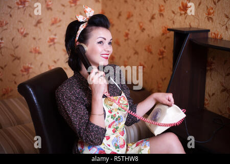 Schöne Frau Hausfrau in Schürze spricht per Telefon. Retro Style, Pin-up. Stockfoto