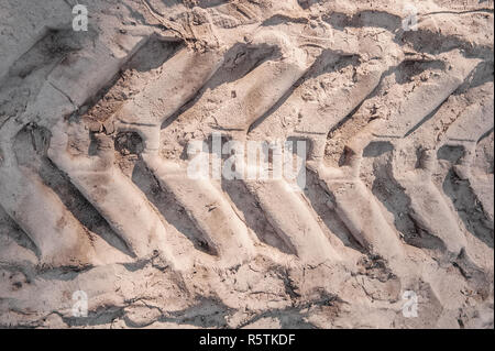 Spuren von PKW-Reifen auf trockenem Sand. Muster in den Sand. Stockfoto
