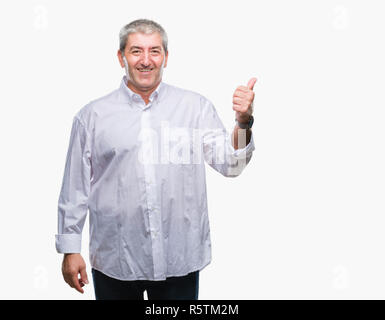 Gut aussehender älterer Mann über isolierte Hintergrund lächelnd mit glücklichen Gesicht und zeigt auf die Seite mit dem Daumen nach oben. Stockfoto