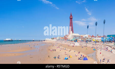 Viele Leute am Sandstrand bei Blackpool Strand Sommer Blackpool Tower und Blackpool North Pier in Blackpool Lancashire England UK GB Europa Stockfoto