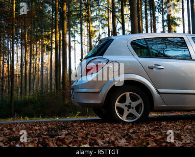 Schließen Sie herauf Bild der Parkplatz auf der Straße in den Wald während des Tages Stockfoto