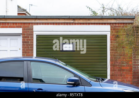 Auto vor ein Garagentor geparkt Anzeigen keine Parkplätze beachten Stockfoto