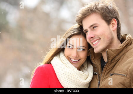 Portrait von ein glückliches Paar in der Liebe weg schauen in einer verschneiten Winter Stockfoto