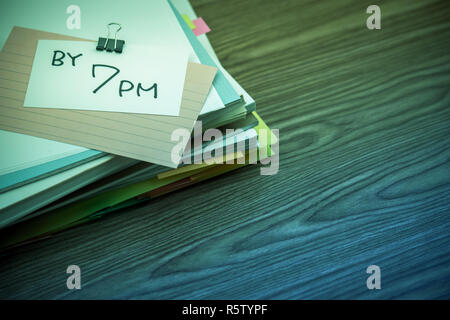 Um 7:00 Uhr Der Stapel der geschäftlichen Dokumente auf dem Schreibtisch Stockfoto