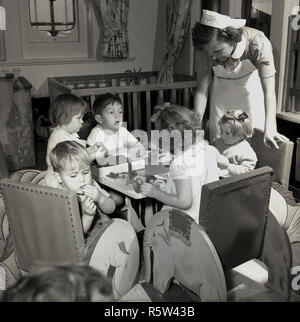 1950, historische, eine uniformierte weibliche Krankenschwester auf der Suche nach jungen Kinder Passagiere eine Union - Schloss steamship an Bord, ein Kreuzfahrtschiff, die Reisende, Fracht und Post über die Weltmeere. Stockfoto