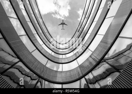 Fliegende Flugzeug und moderne Architektur Gebäude Stockfoto