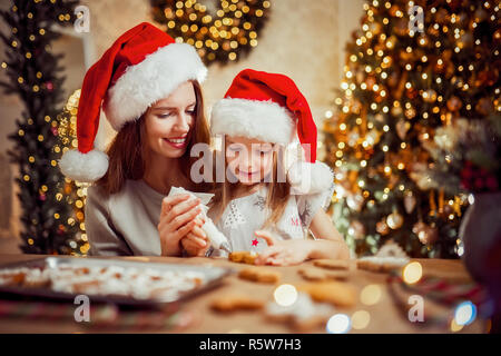 Frohe Weihnachten und schöne Feiertage. Familie Vorbereitung Urlaub essen. Mutter und Tochter kochen Weihnachtsplätzchen. Stockfoto