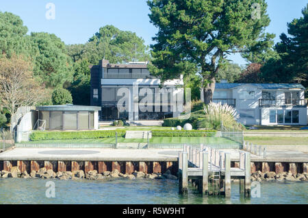 Poole Dorset Großbritannien - 20. Oktober 2018: neue Häuser auf Sandbänken Poole Harbour in Gärten mit Jetty vor Luxus Stockfoto