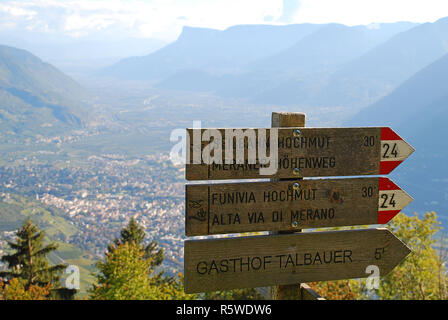 Wandern Zeichen der Meraner Hochalpine Tour (Deutsch: Meraner Höhenweg, Ital.: Alta Via di Meran). Im Tal die Stadt Meran (Südtirol, Italien) Stockfoto