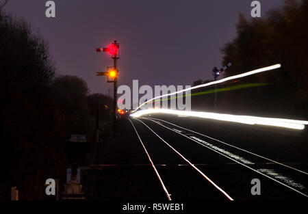 Leichte Spuren von einem Transpennine Express Zug passiert die mechanische Formsignale an Gilberdyke im Dunkeln Stockfoto