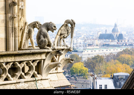 Drei Statuen von Chimären auf die Türme der Kathedrale Notre-Dame de Paris mit Blick auf die Stadt und die Kirche von Saint-Paul-Saint-Louis Stockfoto