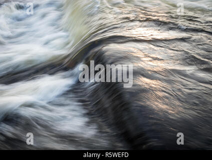 Eine Nahaufnahme des Flusses Nith in Dumfries, Schottland, zeigt das Wasser rauschen über das Netz. Stockfoto