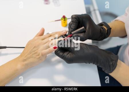 Farbige Maniküre, Nail Malerei. Frau Maniküre, Profi Maniküre, mit Color Gel polish, Nagel- und Handpflege im Beauty Salon Stockfoto