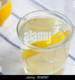 Wasser mit Zitrone im Glas auf Stoff, Seitenansicht. Ernährung, Gewicht Verlust und gesundes Essen. Detox Drink. Stockfoto