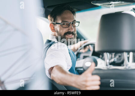 Ansicht von hinten.business Mann hinter dem Lenkrad sitzen Stockfoto