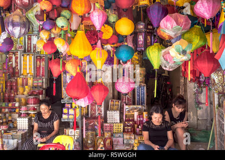 Hanoi, Vietnam - ca. Oktober 2015: Frauen und traditionelle, bunte Lampen in der Straße shop in Hanoi, Vietnam hängen. Stockfoto