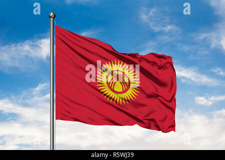 Flagge von Kyrgyzstan winken im Wind gegen Weiße bewölkt blauer Himmel. Kirgisische Flagge. Stockfoto