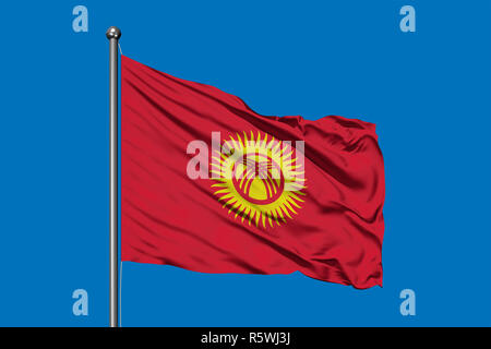 Flagge von Kyrgyzstan winken im Wind gegen den tiefblauen Himmel. Kirgisische Flagge. Stockfoto