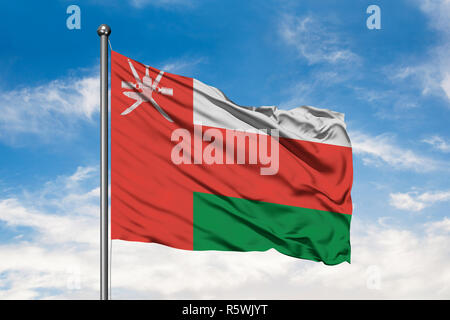 Flagge des Oman winken im Wind gegen Weiße bewölkt blauer Himmel. Omanische Fahne. Stockfoto