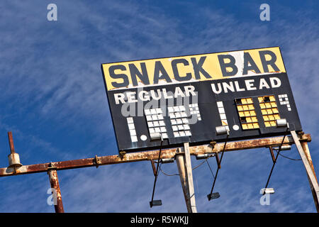 Erhöhte Vintage Gas Station anmelden nack Bar - regelmäßig - Unlead-Benzin, rostigen Metallrahmen, gegen eine verstreute blue sky. Stockfoto