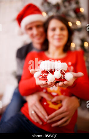 Foto von glücklich verheirateten mit Booties am Hintergrund der Weihnachtsschmuck Stockfoto