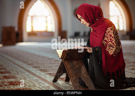 Junge betende Frau, die auf Knien in die Moschee Stockfoto