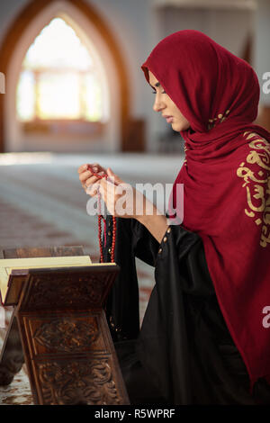 Junge betende Frau, die auf Knien in die Moschee Stockfoto