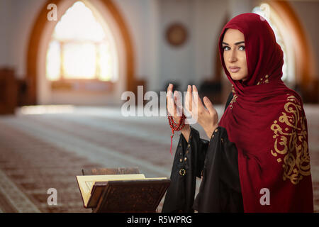 Junge betende Frau, die auf Knien in die Moschee Stockfoto