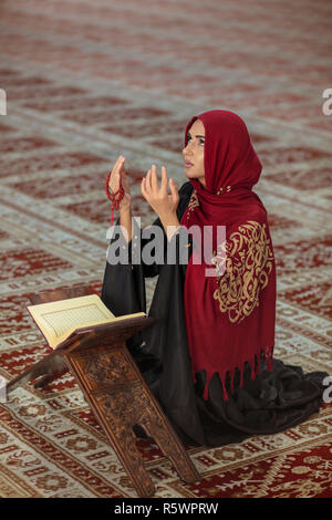 Junge betende Frau, die auf Knien in die Moschee Stockfoto