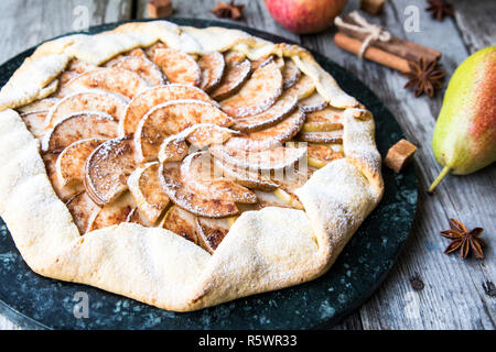 Kuchen mit Äpfeln, Birnen und Zimt auf einem alten hölzernen Hintergrund Stockfoto