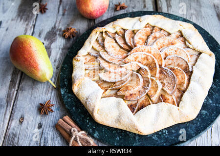 Kuchen mit Äpfeln, Birnen und Zimt auf einem alten hölzernen Hintergrund Stockfoto