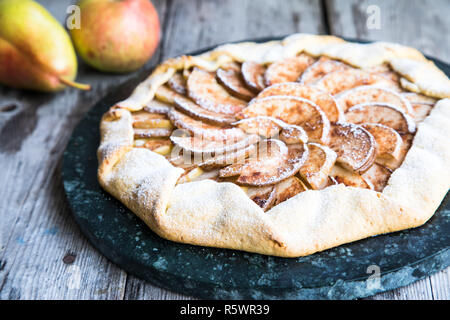 Kuchen mit Äpfeln, Birnen und Zimt auf einem alten hölzernen Hintergrund Stockfoto