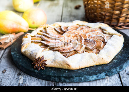 Kuchen mit Äpfeln, Birnen und Zimt auf einem alten hölzernen Hintergrund Stockfoto