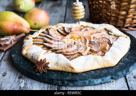 Kuchen mit Äpfeln, Birnen und Zimt auf einem alten hölzernen Hintergrund Stockfoto