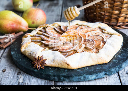 Kuchen mit Äpfeln, Birnen und Zimt auf einem alten hölzernen Hintergrund Stockfoto