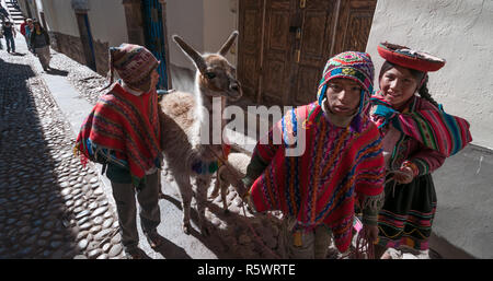 Cuzco, Peru - 30. Juli 2011: Typische Kinder mit einem Lama- und ein Lamm auf der Straße von Cuzco. Stockfoto