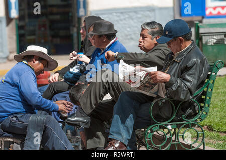 Cuzco, Peru - 30. Juli 2011: Lokale Leute sitzen vor dem Hauptplatz von Cusco. Stockfoto