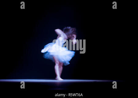 Junge Tänzerin mit Motion verschwommen während der Präsentation des modernen Tanzes zeigen Stockfoto