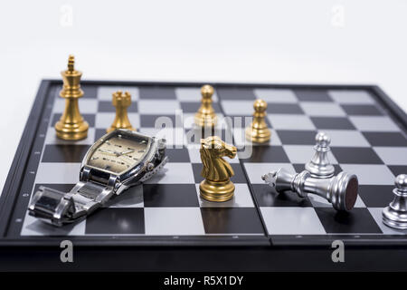 Schachbrett isoliert auf weißem Hintergrund. Die goldenen und silbernen Figuren mit der Hand. Stockfoto