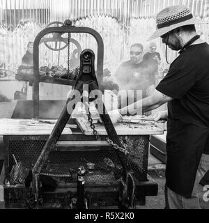 OAKLAND, CA - 6. Juni 2014: Street Art Murmeln Köche Chef am Grill auf eine industrielle Stärke Grill. Kiesige städtischen Umgebung. Schwarze und Weiße quadratische Format. Stockfoto