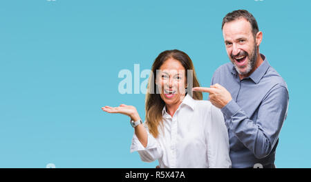 Mittleres Alter hispanic Paar über isolierte Hintergrund erstaunt und lächelt in die Kamera während der Präsentation mit Hand und zeigte mit dem Finger. Stockfoto