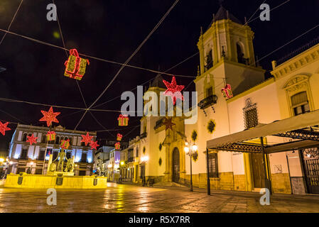 RONDA, SPANIEN - 12. Dezember 2017: Kirche Unserer Lieben Frau (Iglesia de Nuestra Señora del Socorro) an der Plaza del Socorro square beleuchtet mit Weihnachten ho Stockfoto