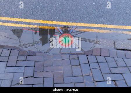 Pfütze Reflexionen der Big Wheel, die in Leeds City Centre ist für die festliche Jahreszeit. Stockfoto