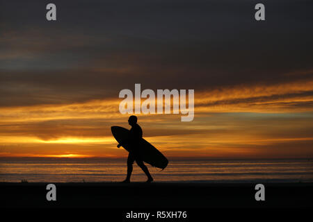 San Diego, CA, USA. 24 Nov, 2018. November 30, 2018, San Diego, Kalifornien, USA - ein Surfer Wanderungen entlang der Küste bei Sonnenuntergang in Windansea Beach in der La Jolla Gegend von San Diego. Credit: KC Alfred/ZUMA Draht/Alamy leben Nachrichten Stockfoto