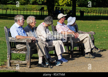 Senioren sitzt auf der Bank an einem sonnigen Tag in Higginson Park, Marlow, Buckinghamshire, England Vereinigtes Königreich Großbritannien Stockfoto
