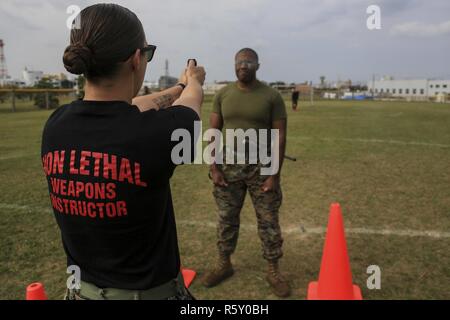 Us Marine Corps Cpl. Jenna Cauble, nicht-tödliche Waffen Ausbilder, mit Propst Marschallamt, Marine Corps Base Camp Butler, führt Oleoresin Capsaicin (OC) Spray zu US-Marines zugeordnet vorübergehend zusätzliche Pflicht, Propst von Marshal Officeas Teil während einer Sicherheit Augmentation Force (SAF) Qualifikationsturnier auf Lager Kinser, Okinawa, Japan, 14. April 2017. Die SAF Marines sind erforderlich Stufe 1 OC Kontamination zu empfangen, um zu wissen, wie der ordnungsgemäße Funktion und Sicherheit bieten, während Sie von der Spray berührt wird. Stockfoto