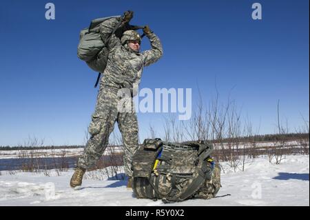 Sgt. Paul Mampreian, ein Eingeborener von Chicago, Illinois, auf das erste Bataillon zugeordnet, 501 Fallschirm Infanterie Regiment, 4 Infantry Brigade Combat Team (Airborne), 25 Infanterie Division, U.S. Army Alaska, lädt seine Jump Gear nach Durchführung der Luft Ausbildung bei Joint Base Elmendorf-Richardson, Alaska, 13. April 2017. Die Soldaten der 4/25 gehören zu den nur American Airborne Brigade im Pazifik und sind geschult in der Luft Manöver bei extrem kalten Wetterbedingungen/Höhe Umgebungen zur Unterstützung der Bekämpfung, Partnerschaft und Katastrophenhilfe Operationen auszuführen. Stockfoto