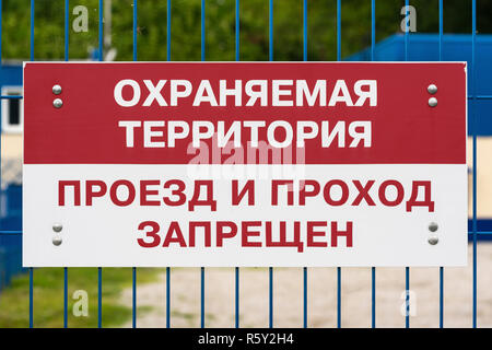 Rote und weiße Verbotsschild am grünen Gitter Metallzaun, Text in Russisch: Geschützter Bereich, Wandern und Passage ist verboten. Stockfoto